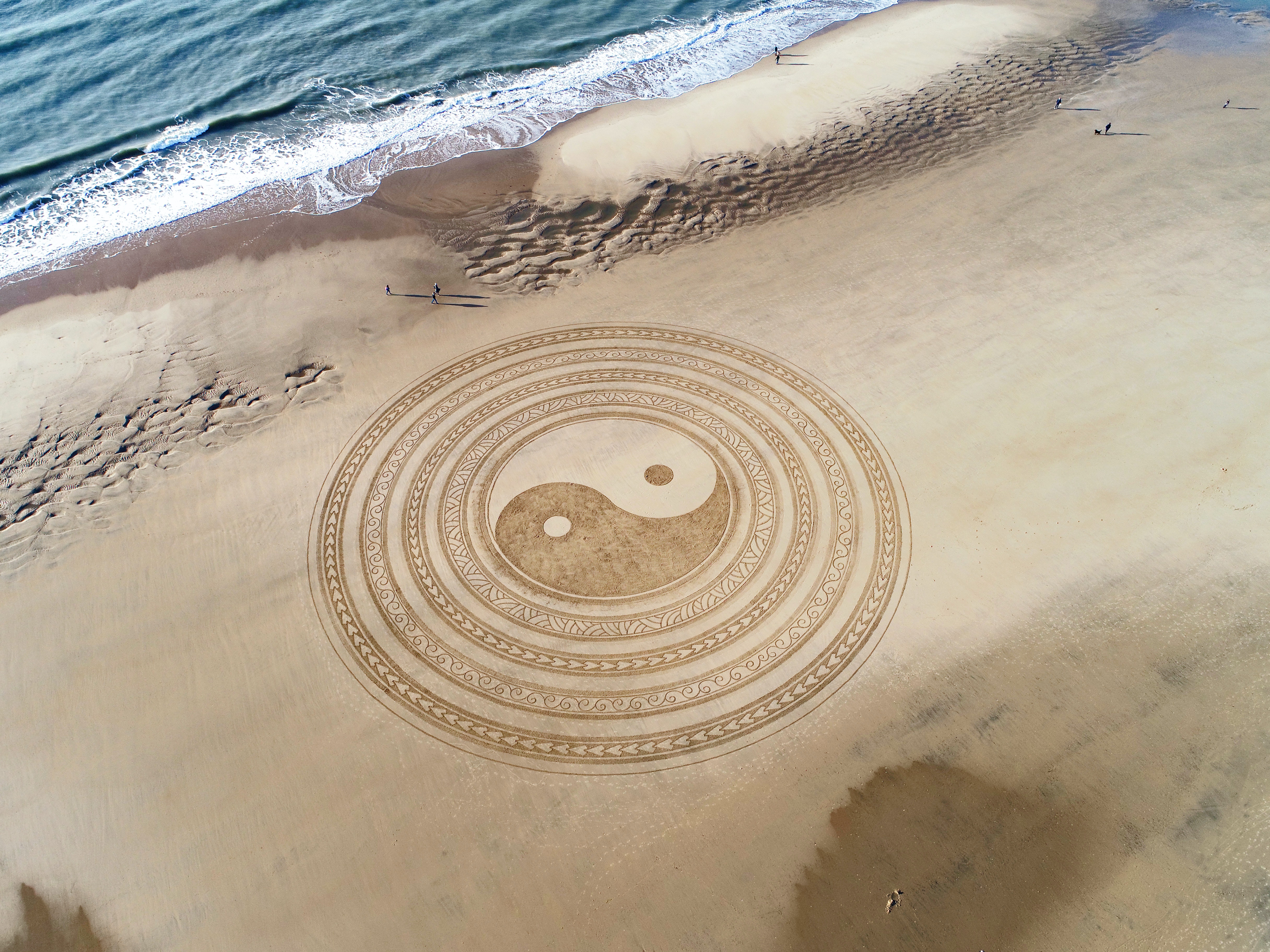yin en yang logo in het zand